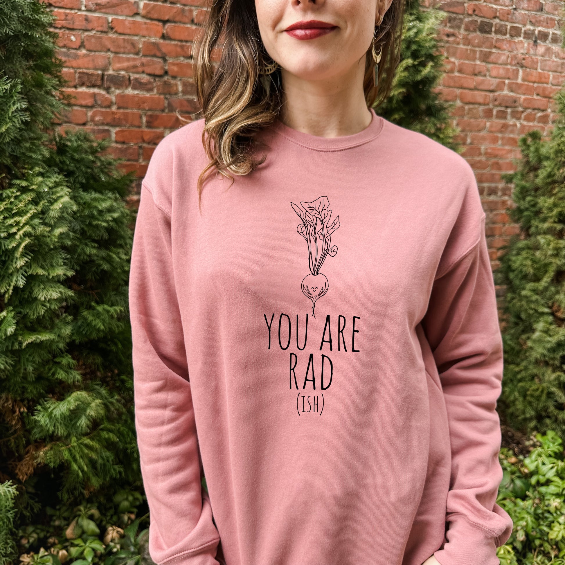 a woman wearing a pink sweatshirt that says you are rad