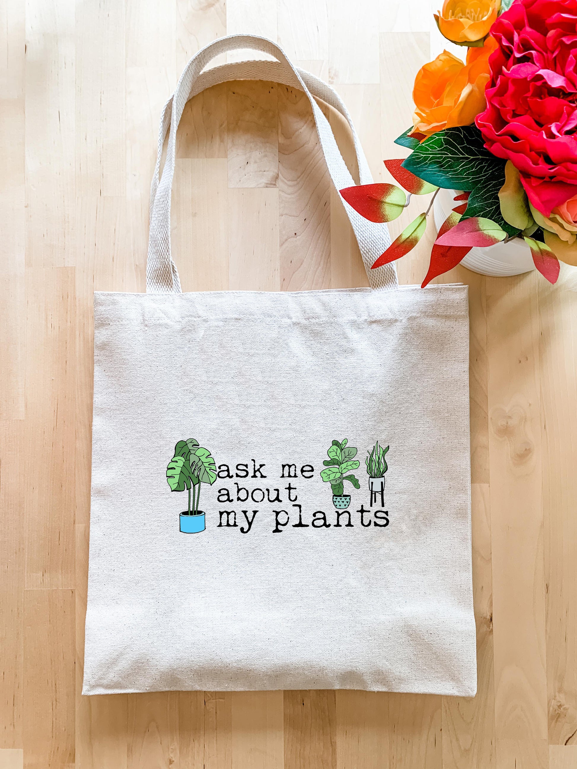 a white tote bag with the words ask me about my plants printed on it