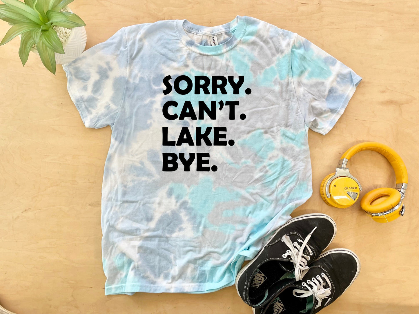 a t - shirt that says sorry can't lake bye next to headphones