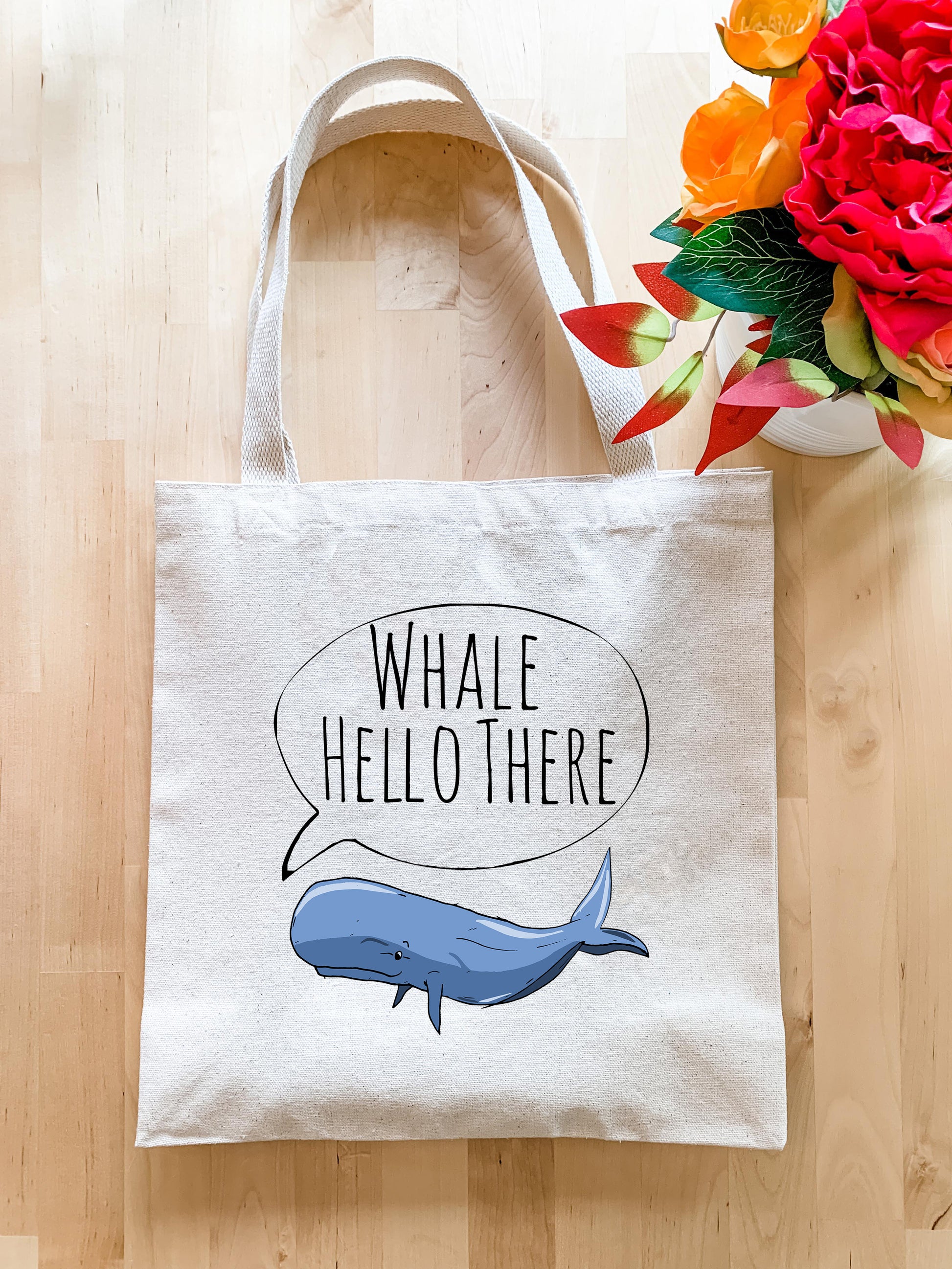 a white tote bag with a whale saying whale hello there