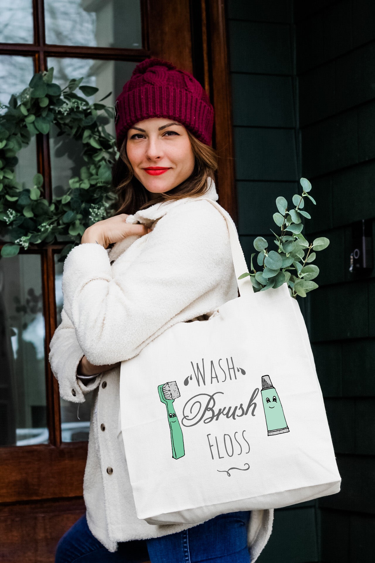 a woman carrying a white bag that says wash brush floss