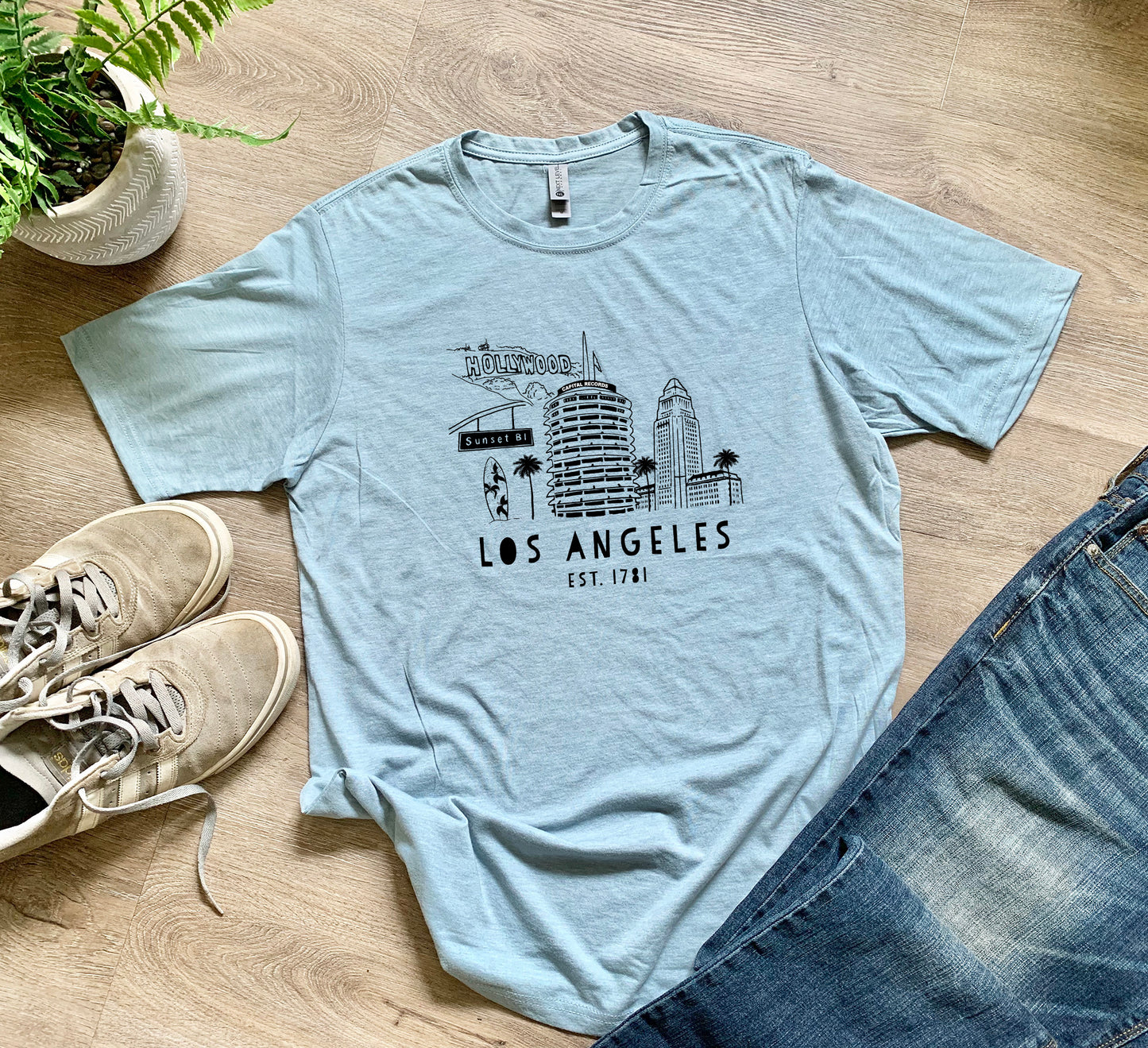 a t - shirt that says los angeles on it next to a pair of jeans