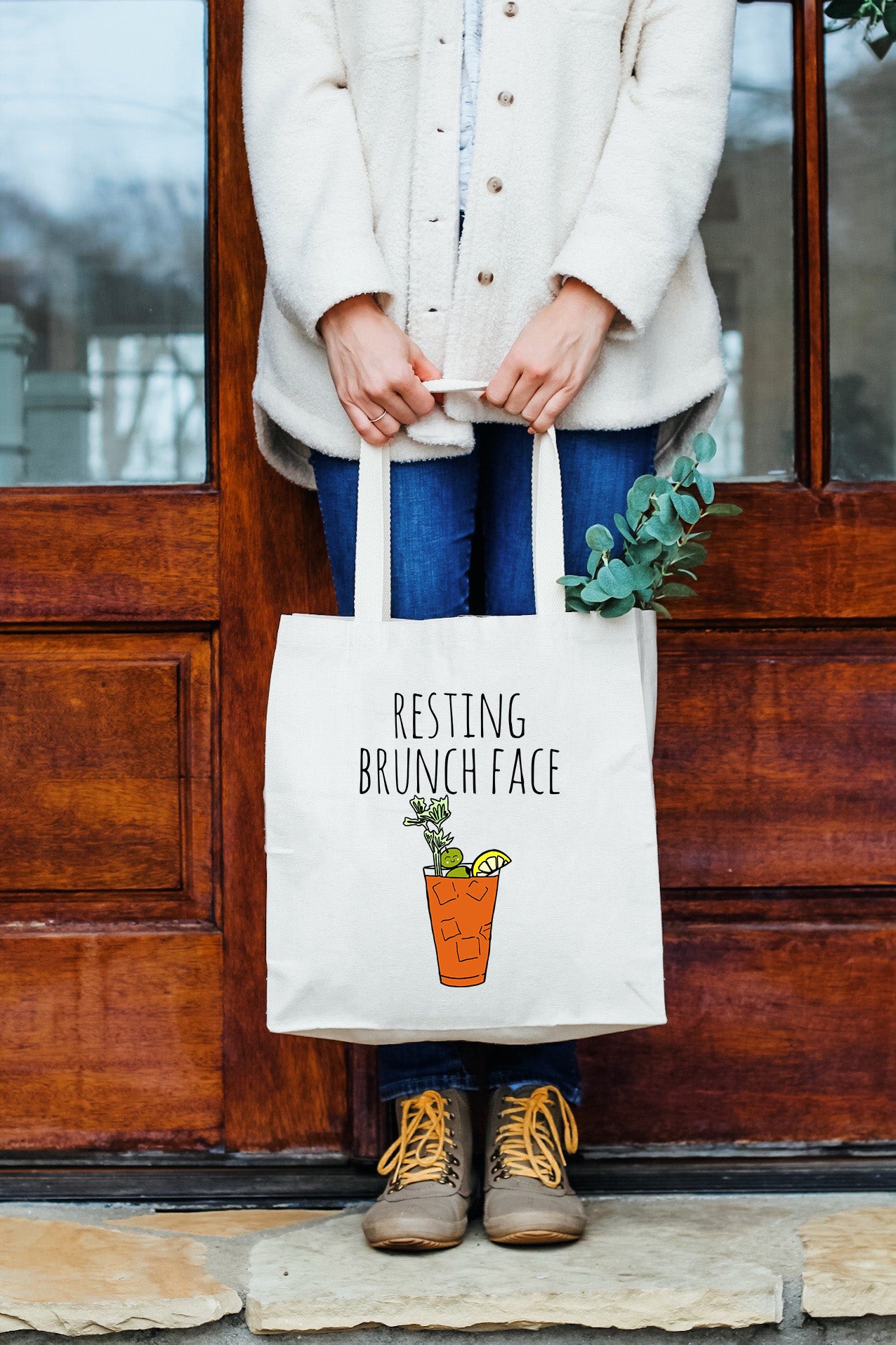 a woman holding a white bag that says resting brunch face