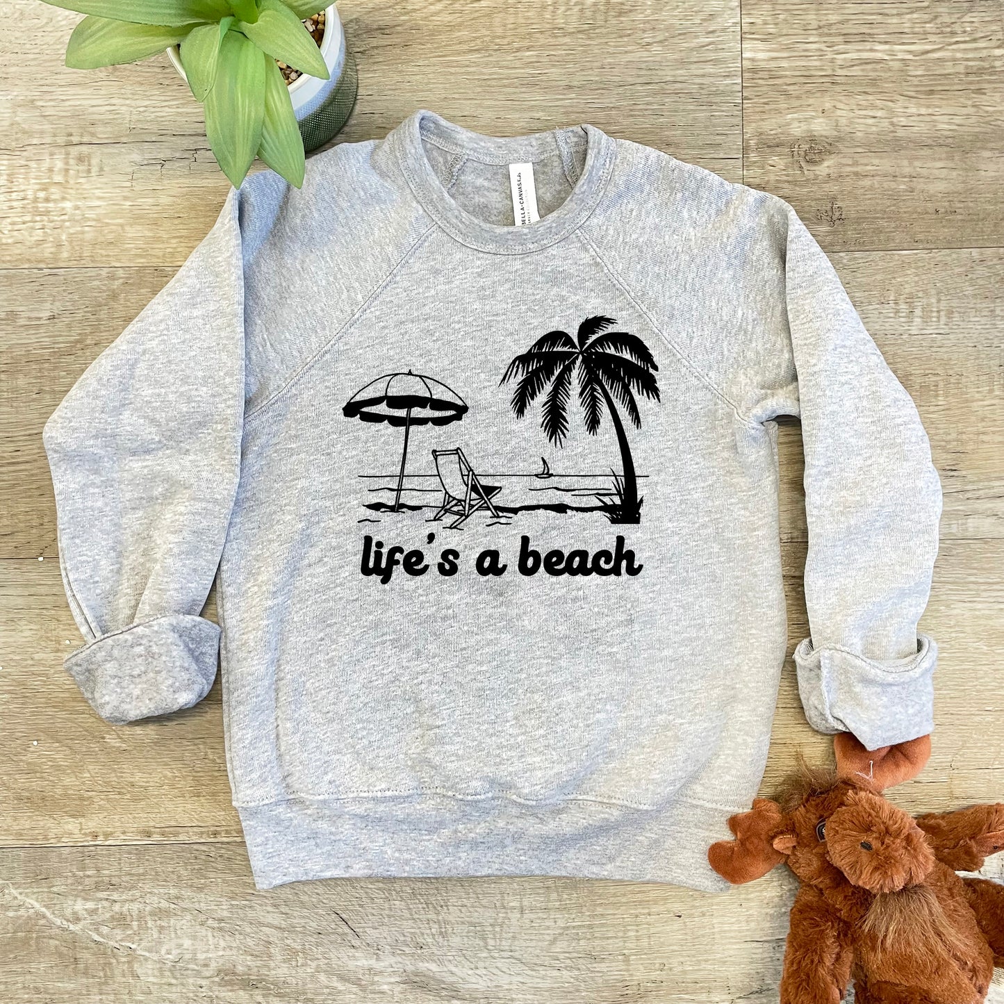 a sweatshirt that says life's a beach with a beach chair and umbrella