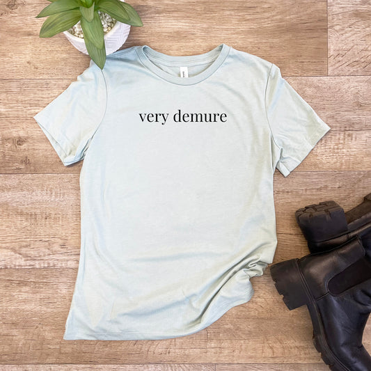 a t - shirt that says very demure next to a pair of black boots