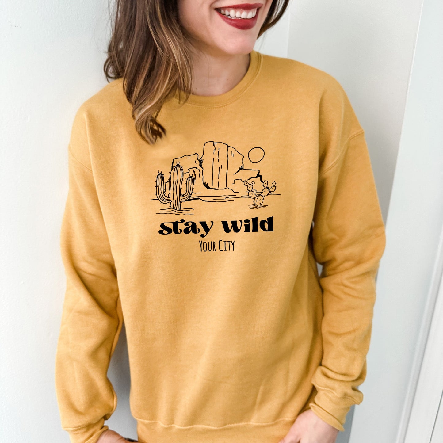 a woman wearing a yellow sweatshirt with a cactus on it