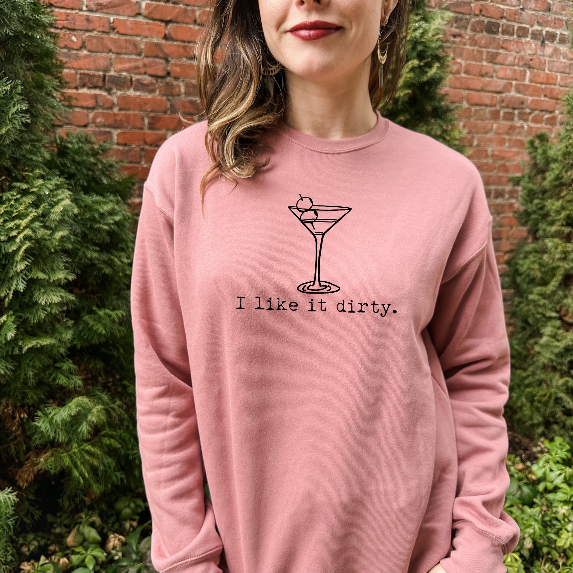 a woman wearing a pink sweatshirt that says i like it dirty