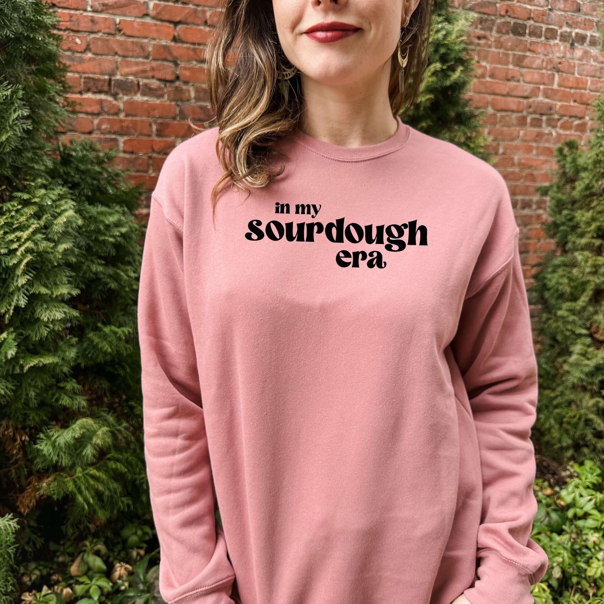 a woman standing in front of a brick wall