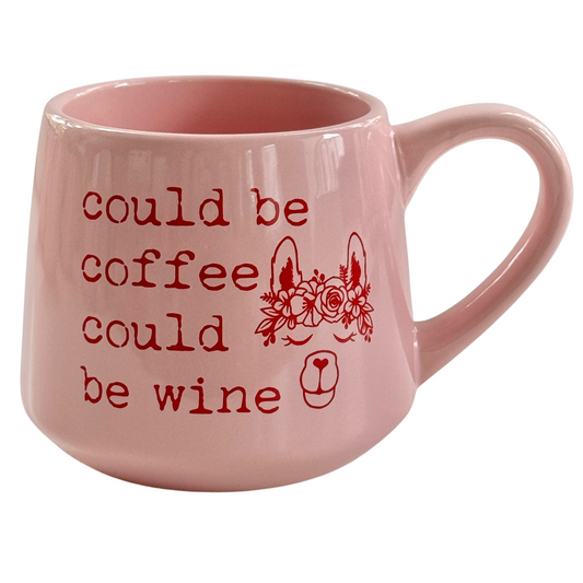 a pink coffee mug with red writing on it