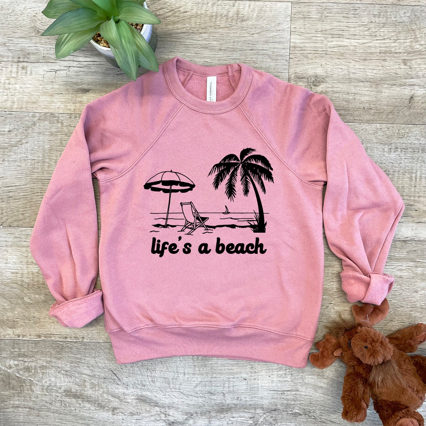 a pink sweatshirt that says life's a beach next to a teddy bear