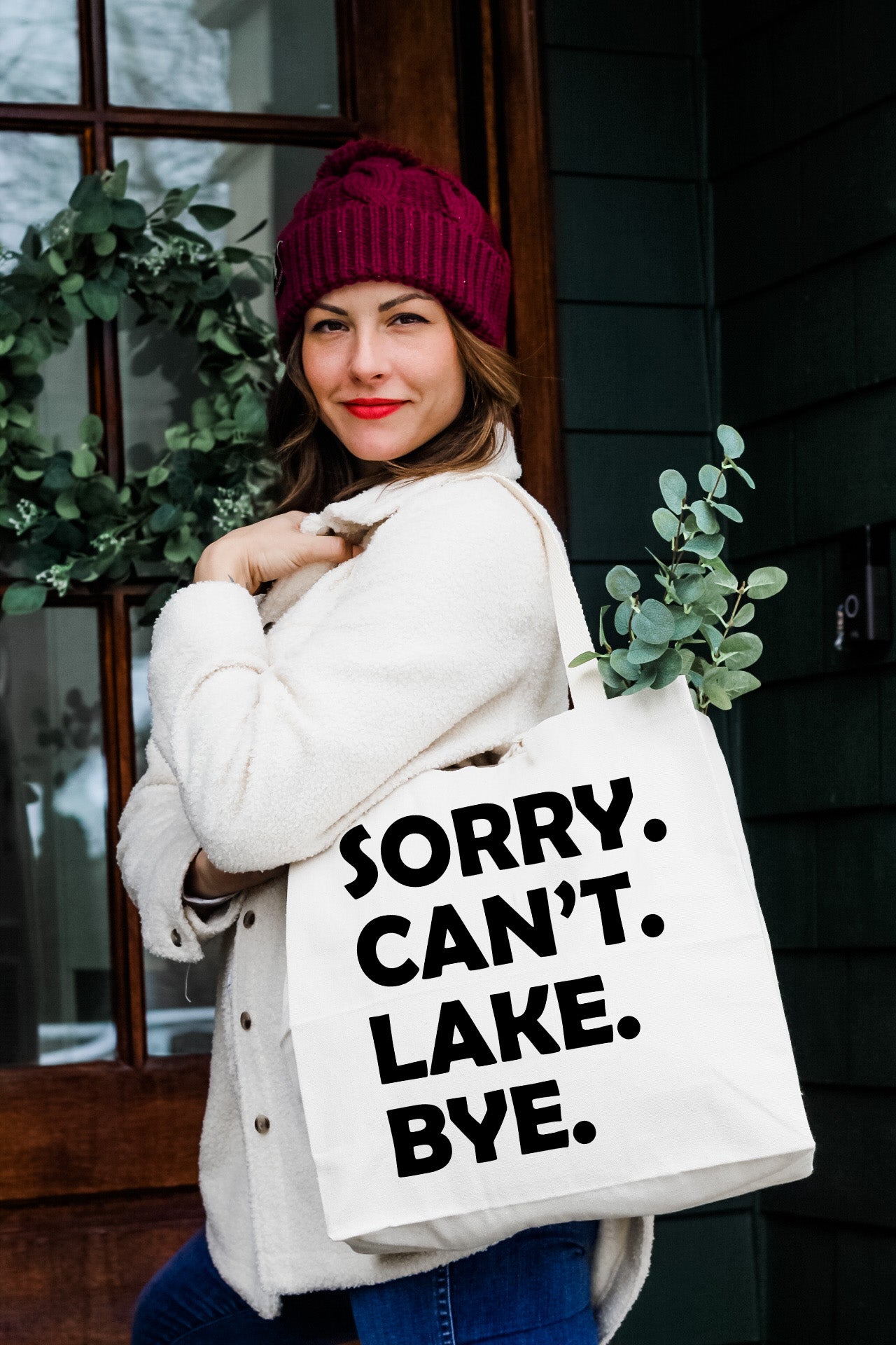 a woman holding a white bag that says sorry can't lake bye