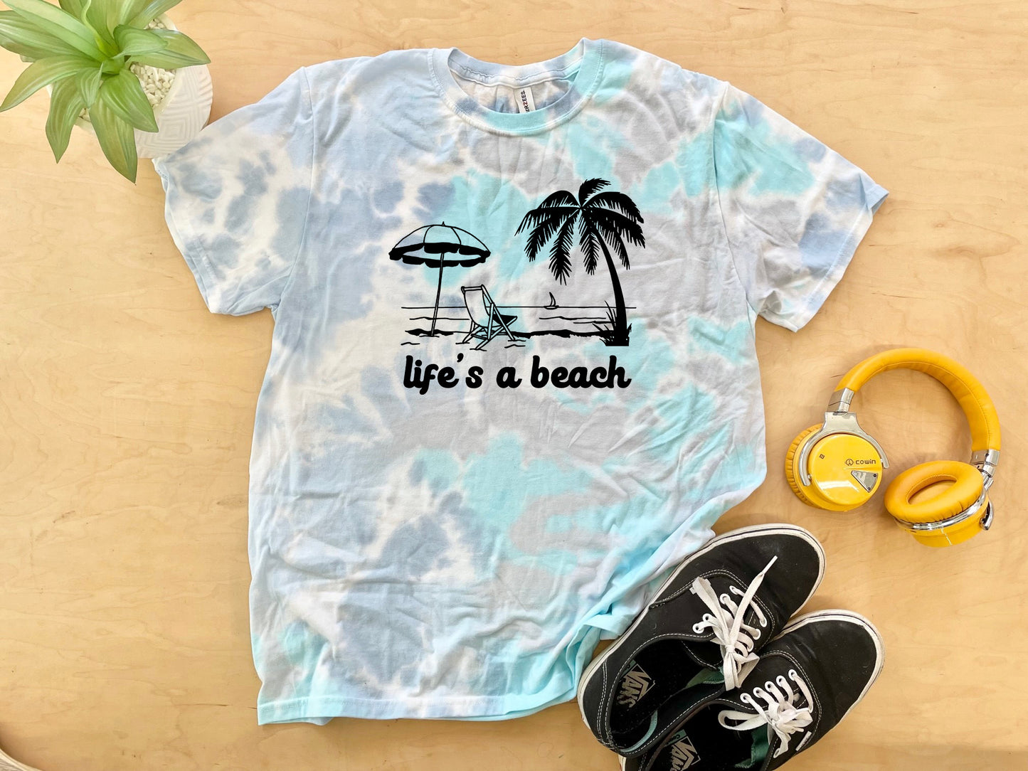 a shirt that says life's a beach next to a pair of headphones