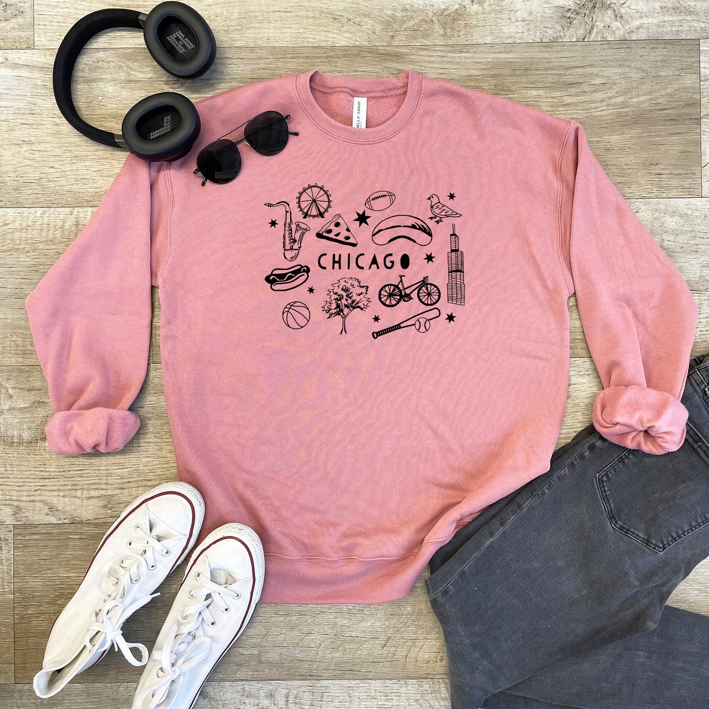 a pink chicago sweatshirt with a pair of headphones and a pair of black head