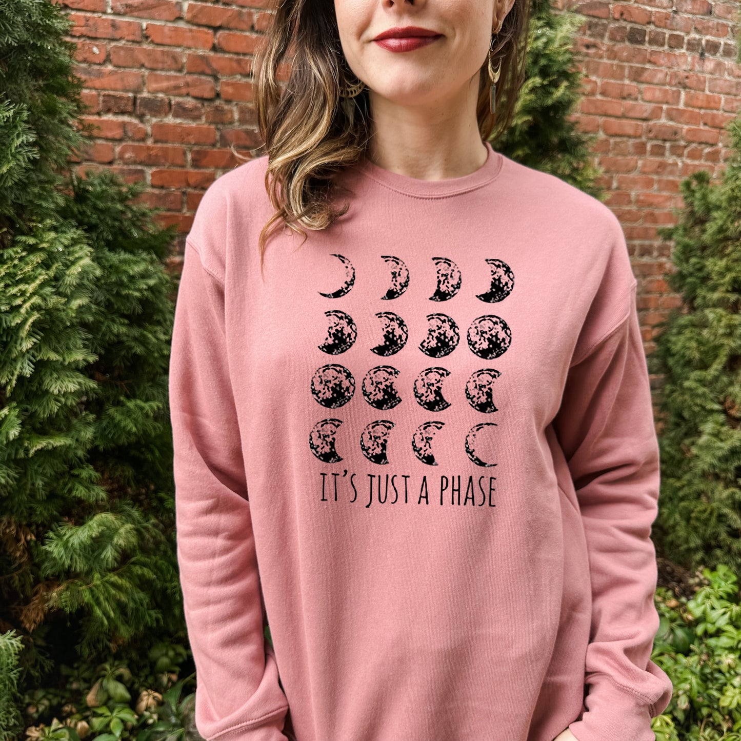 a woman wearing a pink sweatshirt that says it's just a phase