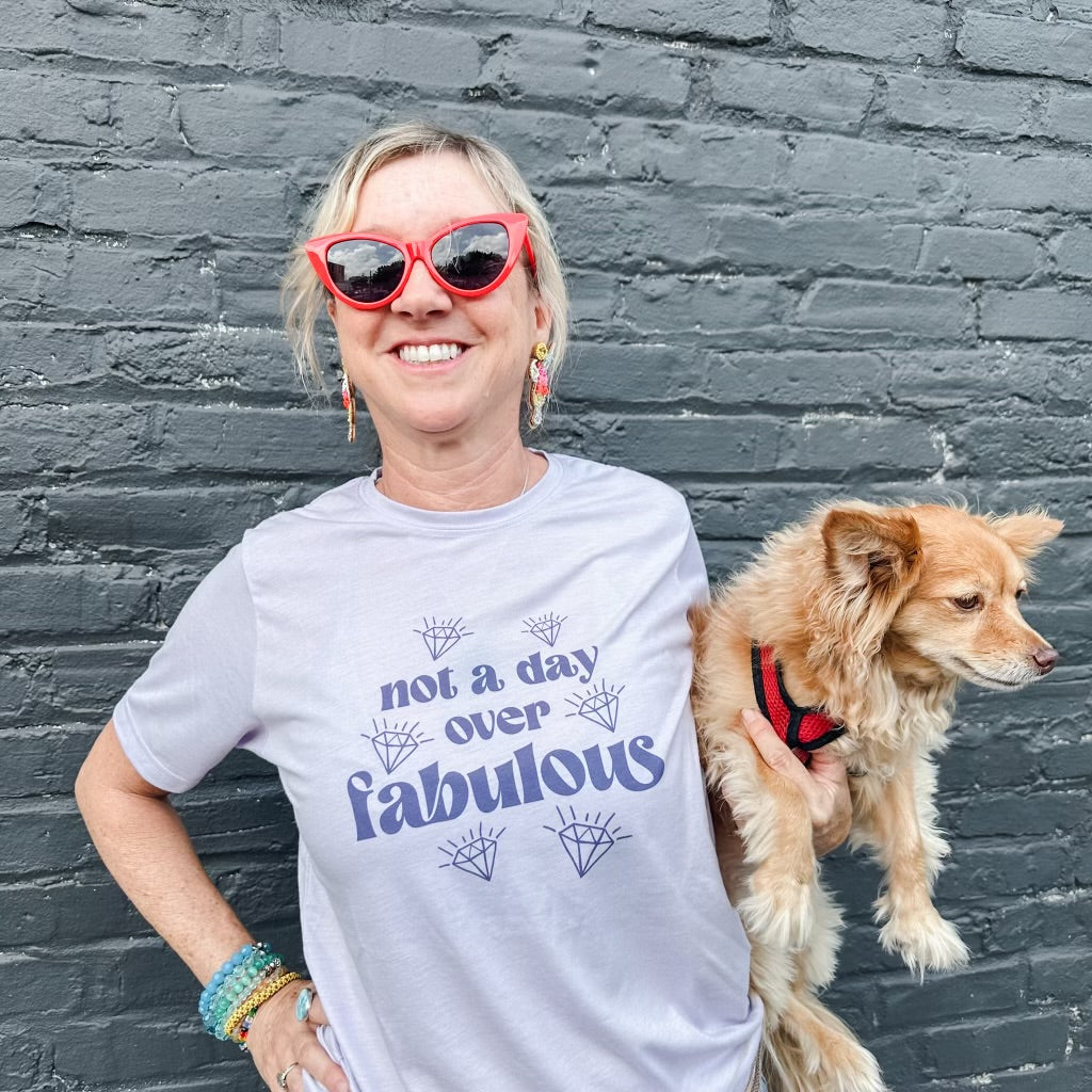 a woman wearing a t - shirt that says not a day is over fabulous with