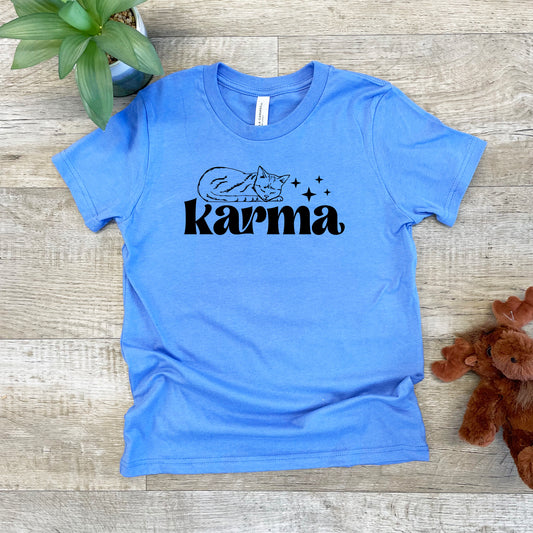 a blue t - shirt with the word karma on it next to a teddy bear