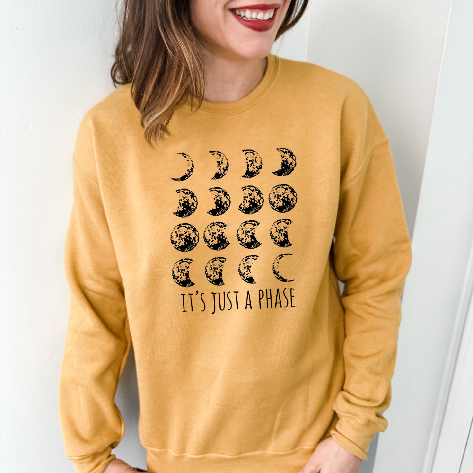 a woman wearing a yellow sweatshirt that says it's just a phase