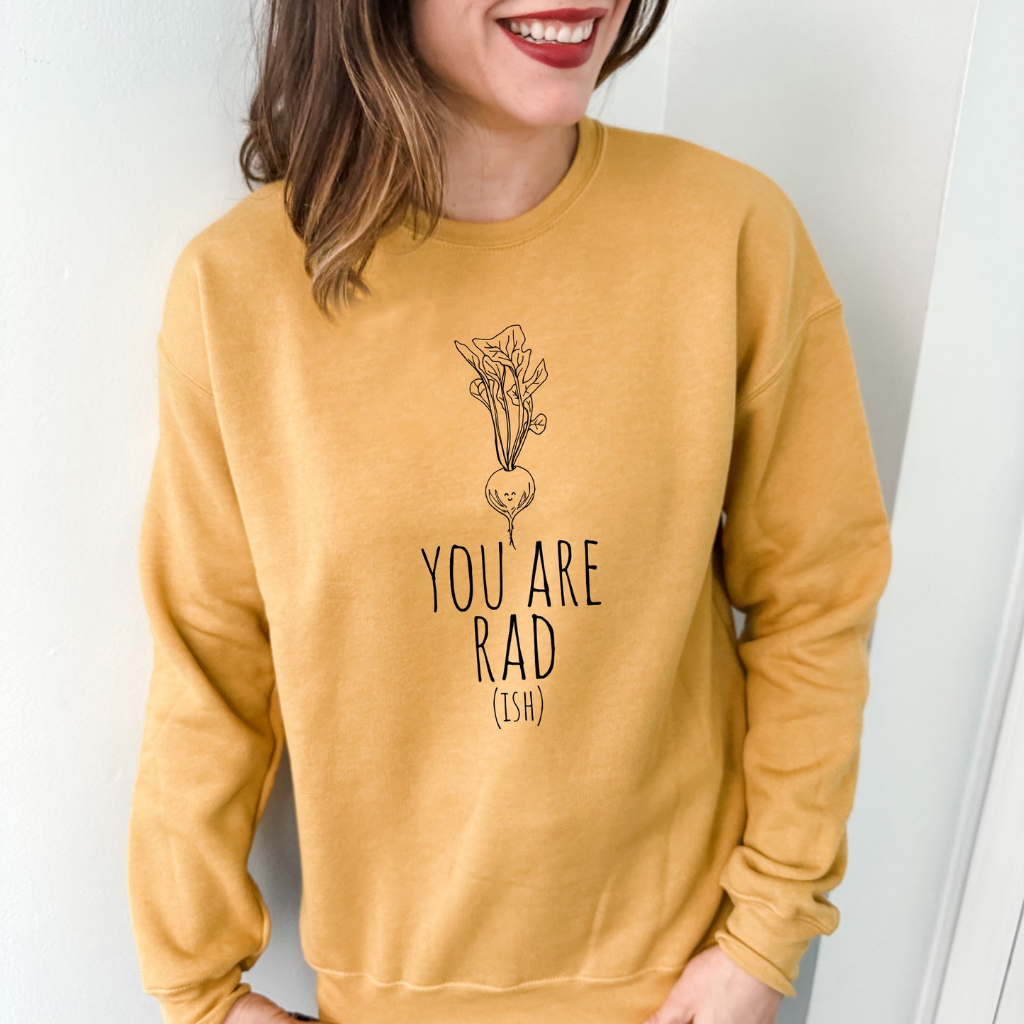 a woman wearing a yellow sweatshirt with the words you are rad printed on it