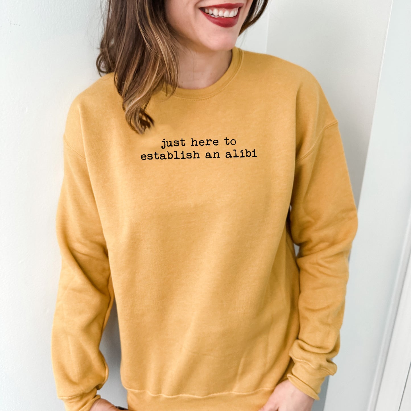 a woman wearing a yellow sweatshirt that says, just here to enaction an