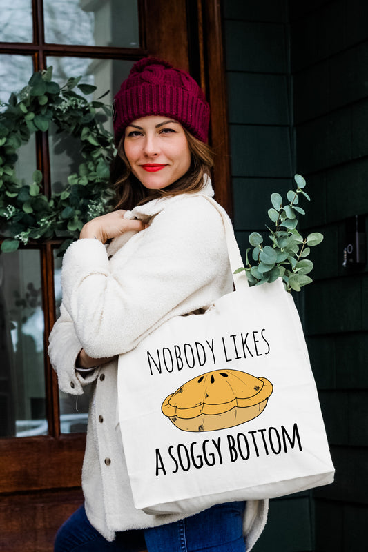 a woman holding a bag that says nobody likes a soggy bottom