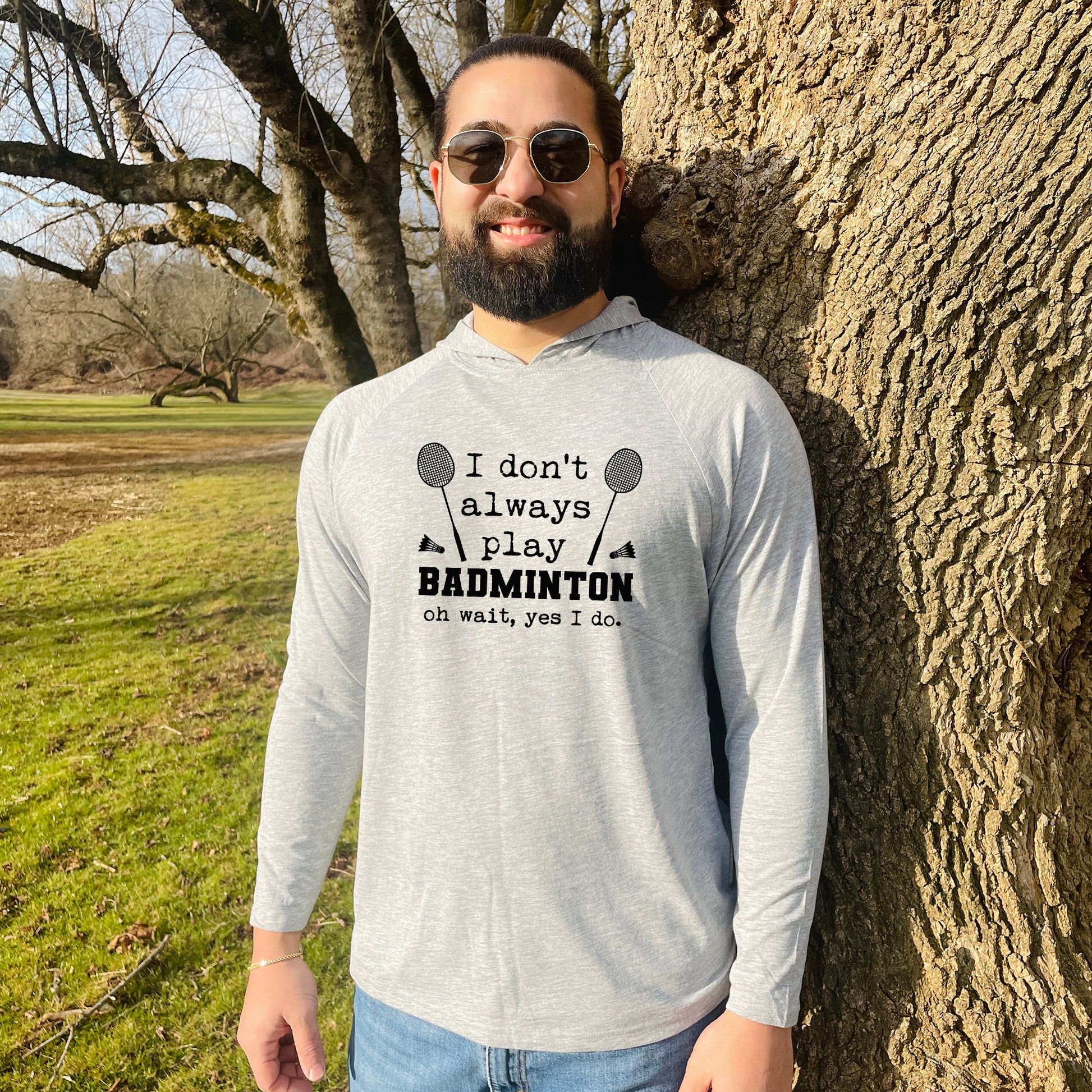 a man standing next to a tree wearing sunglasses