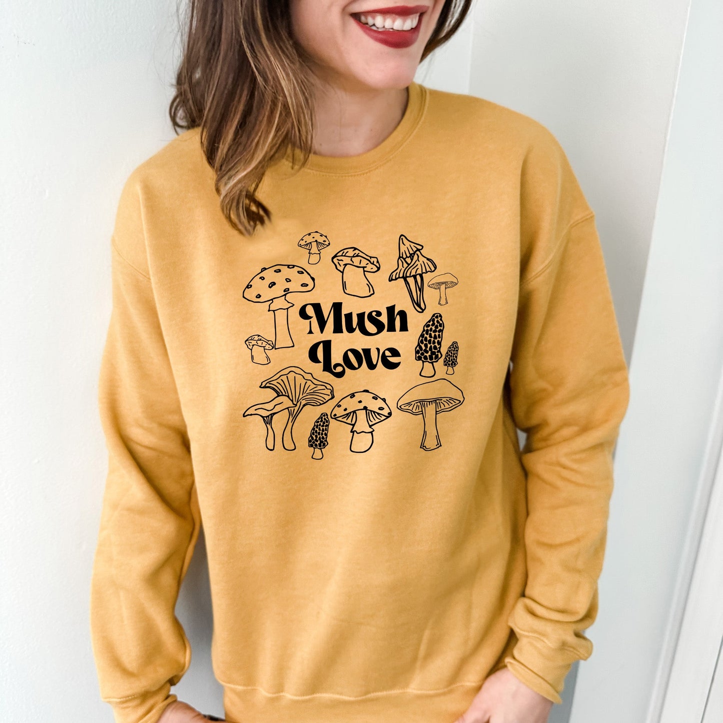 a woman wearing a yellow sweatshirt with mushrooms on it