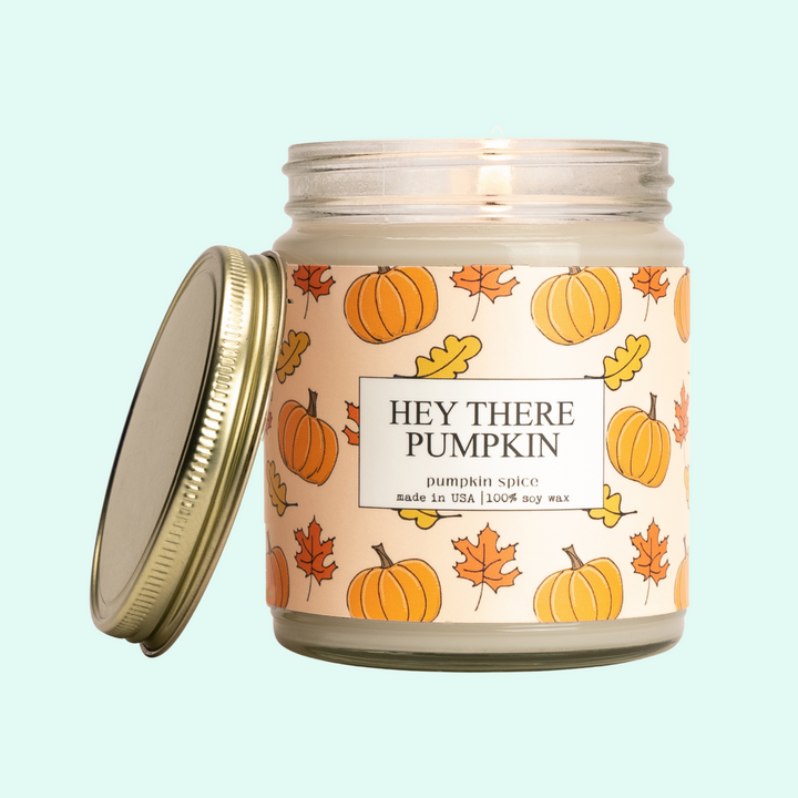 a candle with a lid that says hey there pumpkin