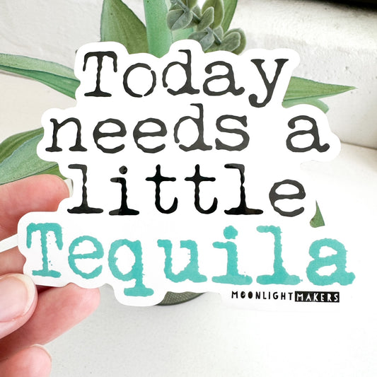 a hand holding a sticker that says today needs a little tequila