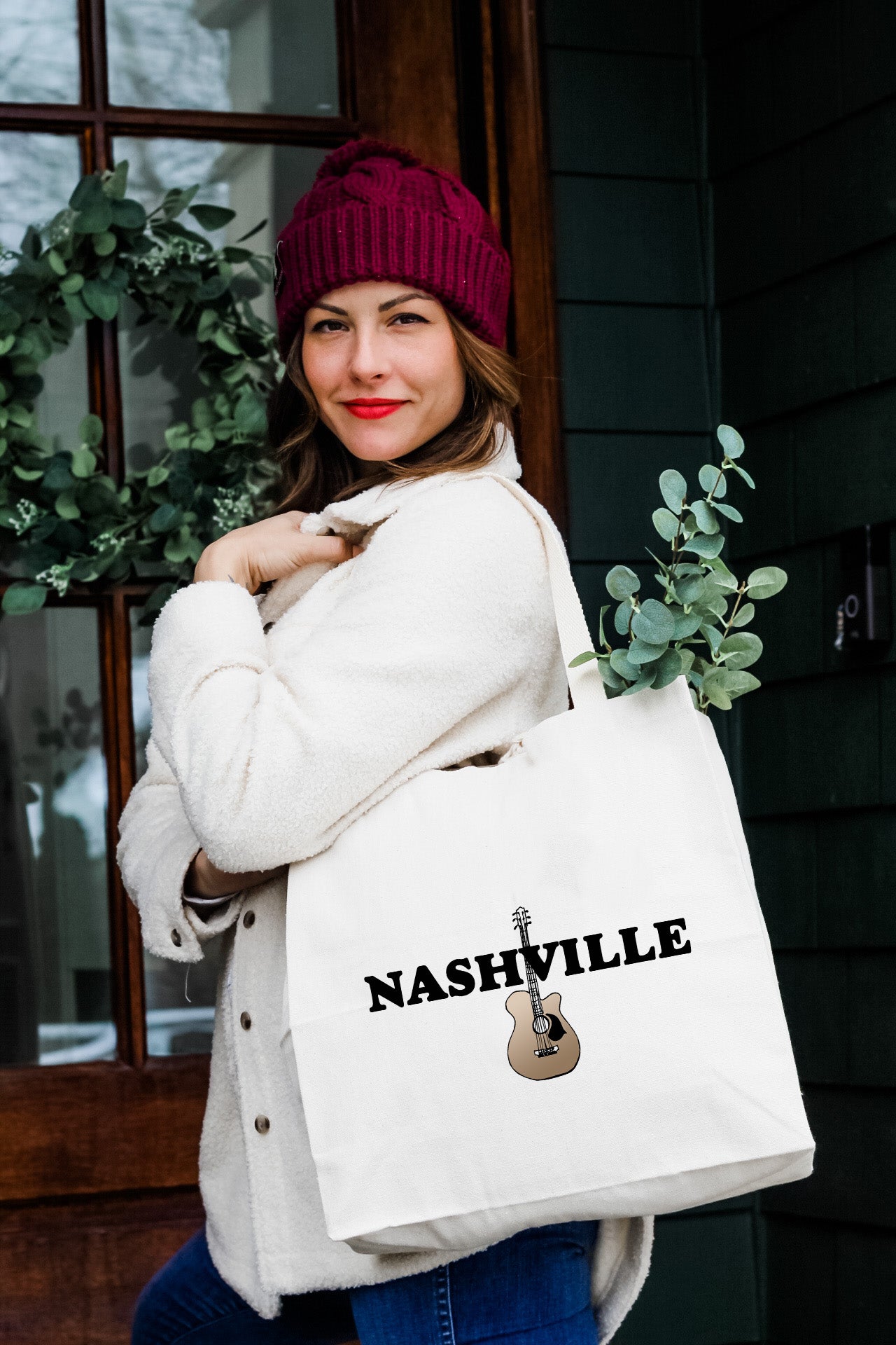 a woman carrying a white nashville tote bag