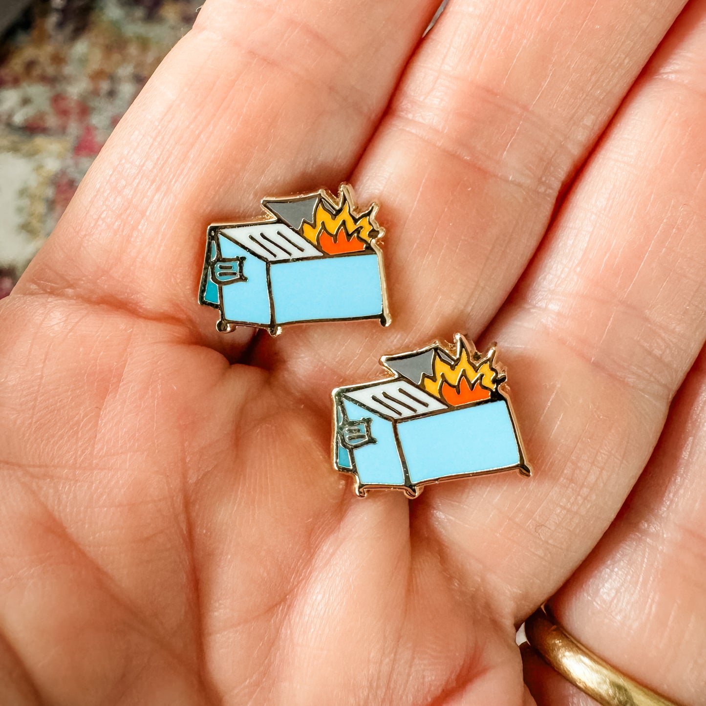 a person holding two small blue and orange pins