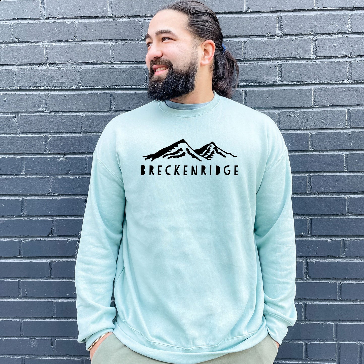 a man standing in front of a brick wall