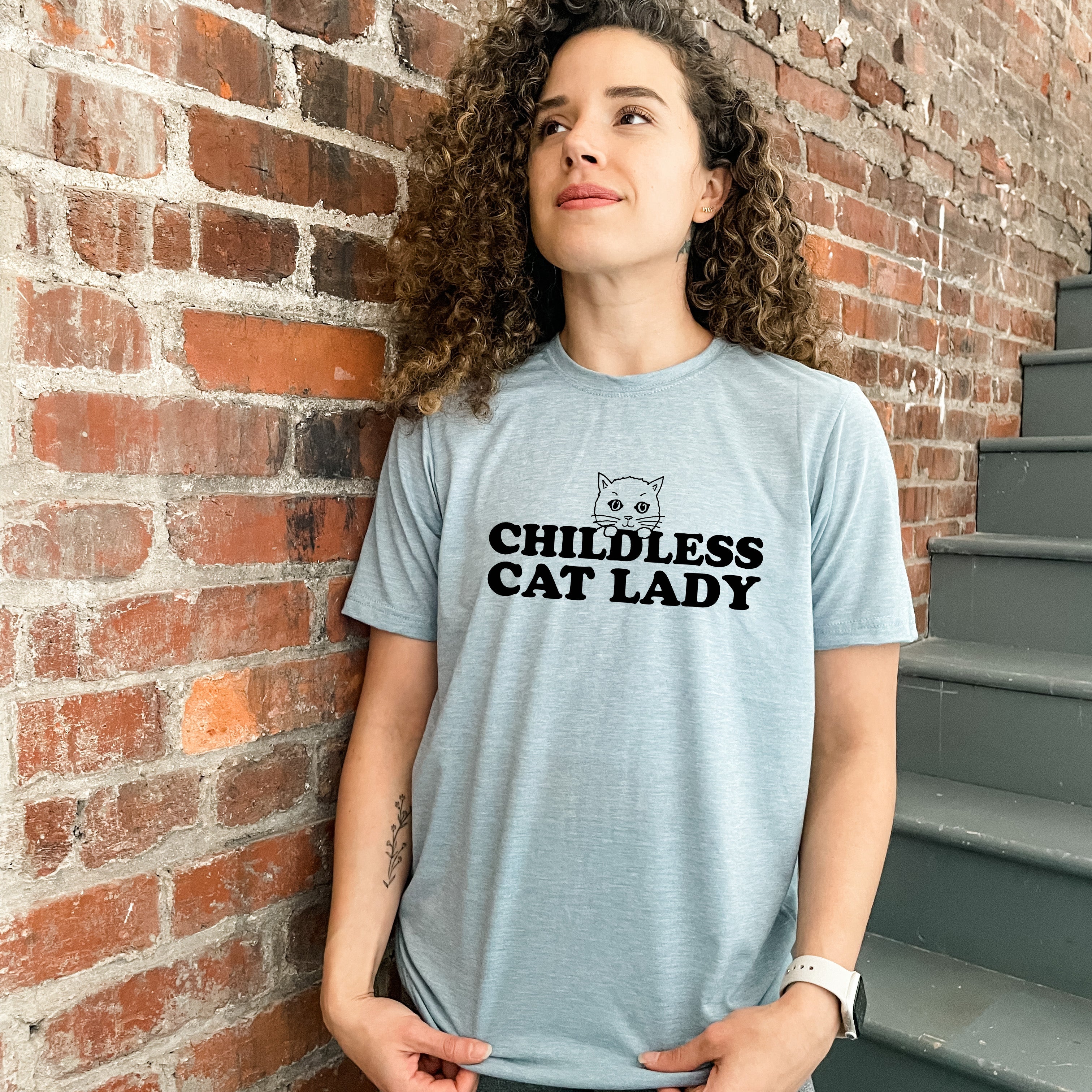 a woman standing in front of a brick wall