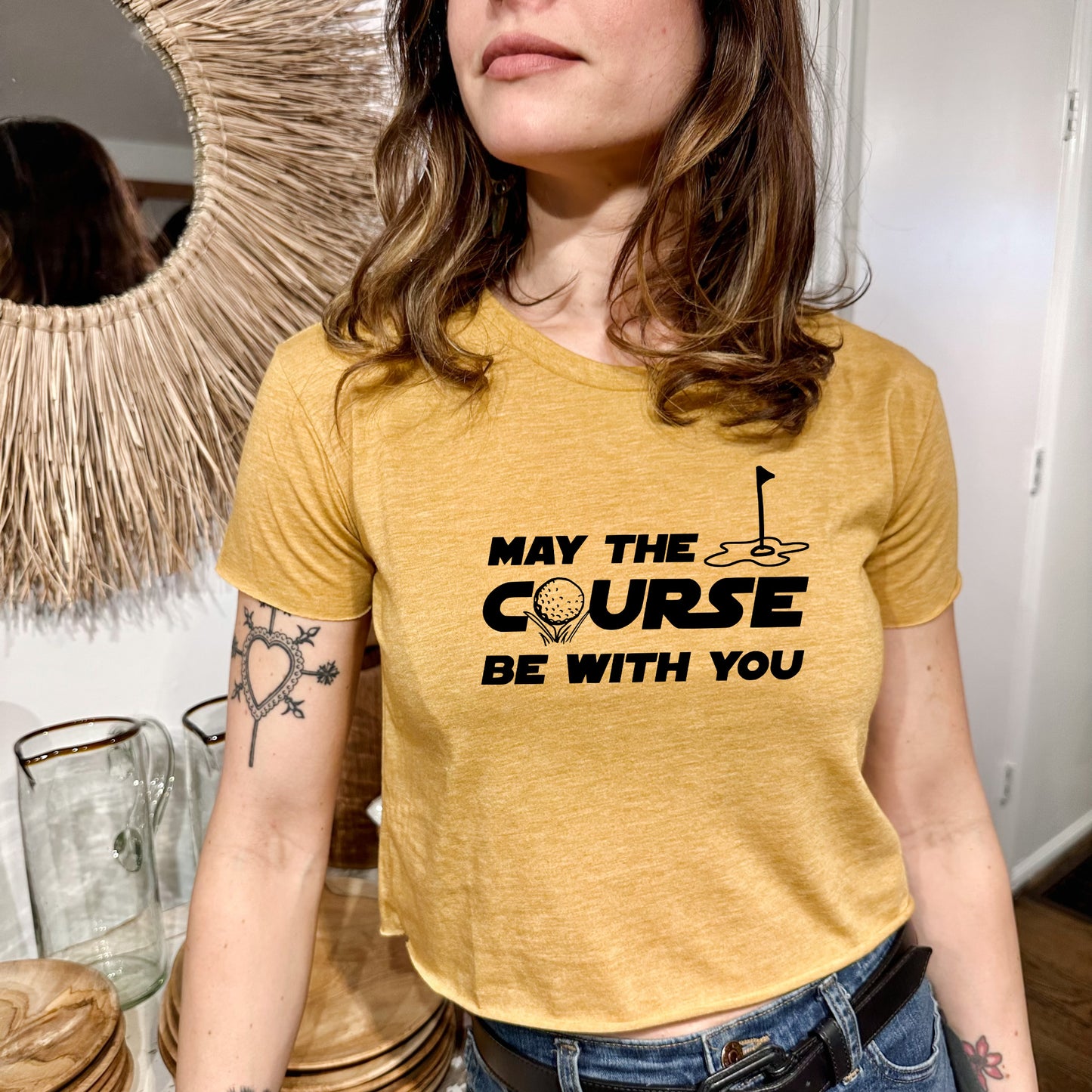 a woman wearing a yellow t - shirt that says may the course be with you
