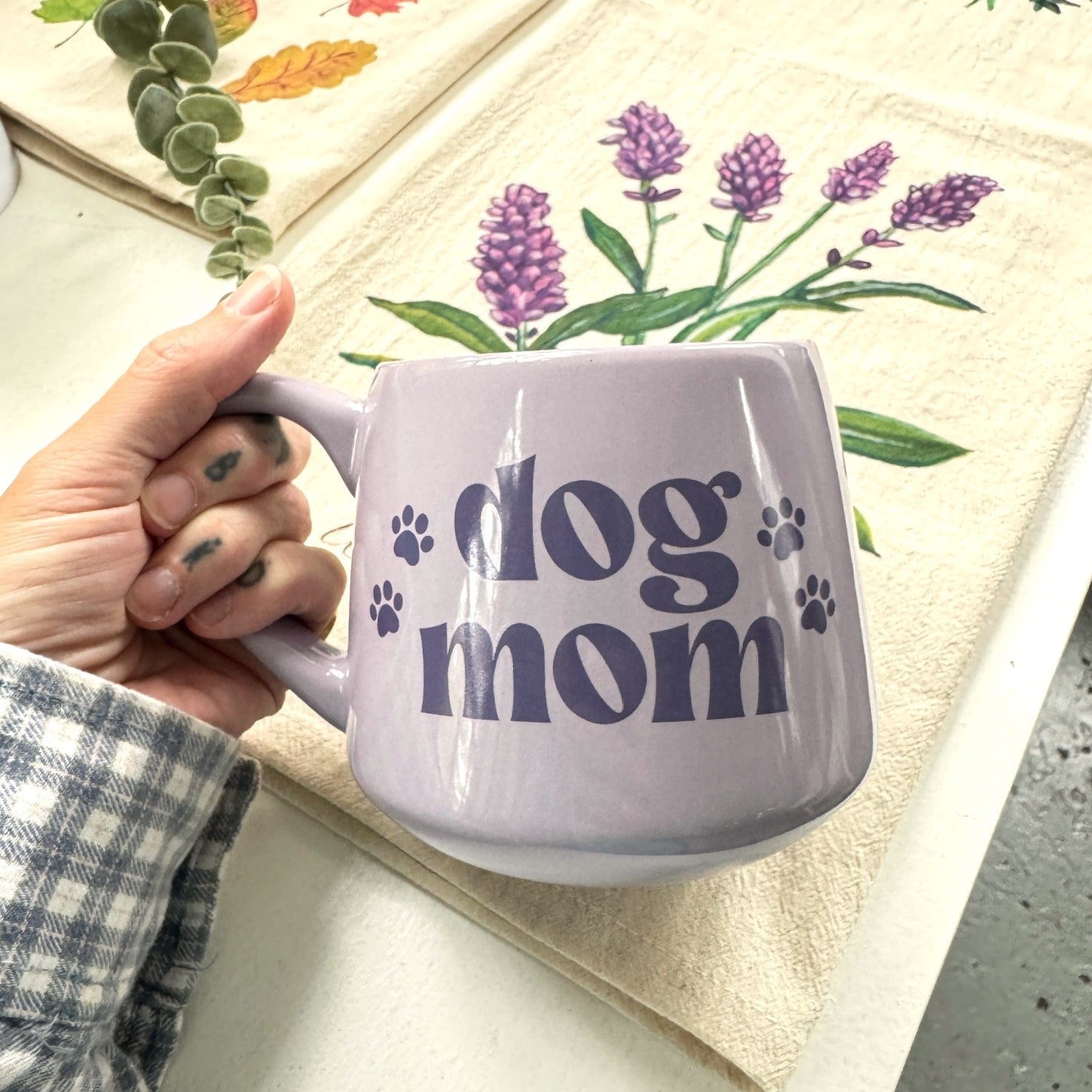 a person holding a coffee mug with a dog mom design on it