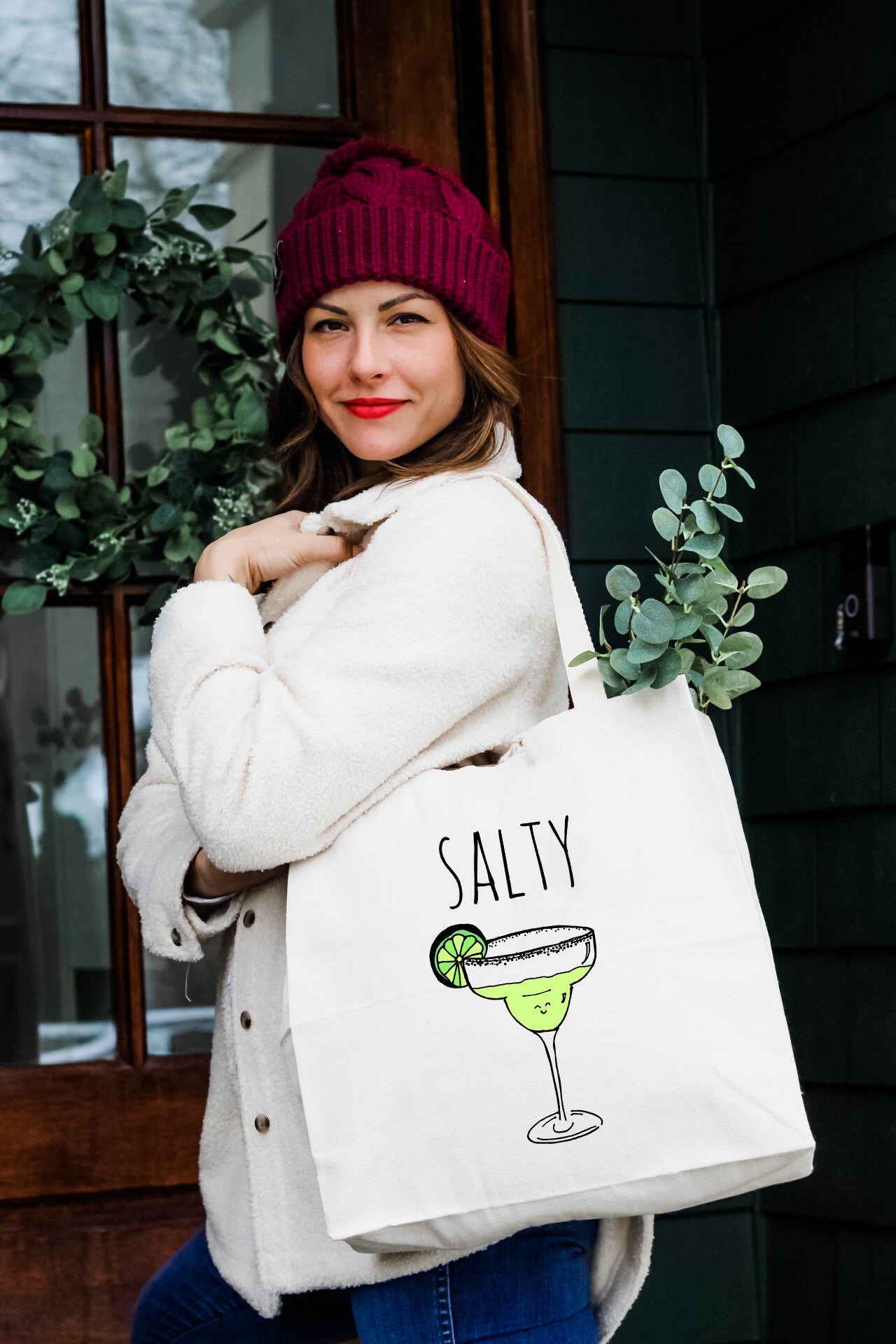 a woman carrying a white bag that says salty