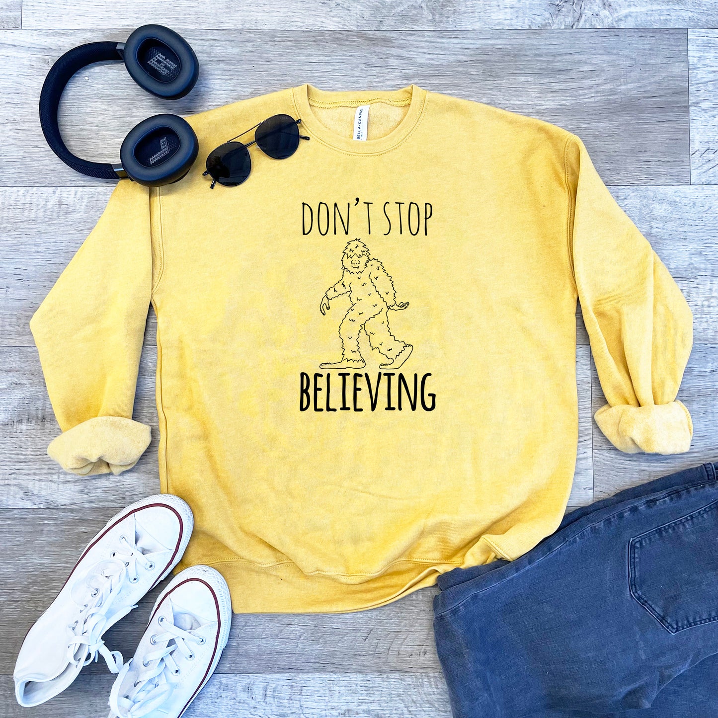 a yellow sweatshirt that says, don't stop believing