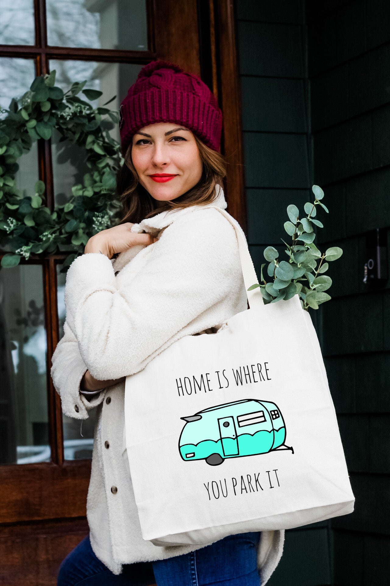 a woman carrying a bag that says home is where you park it