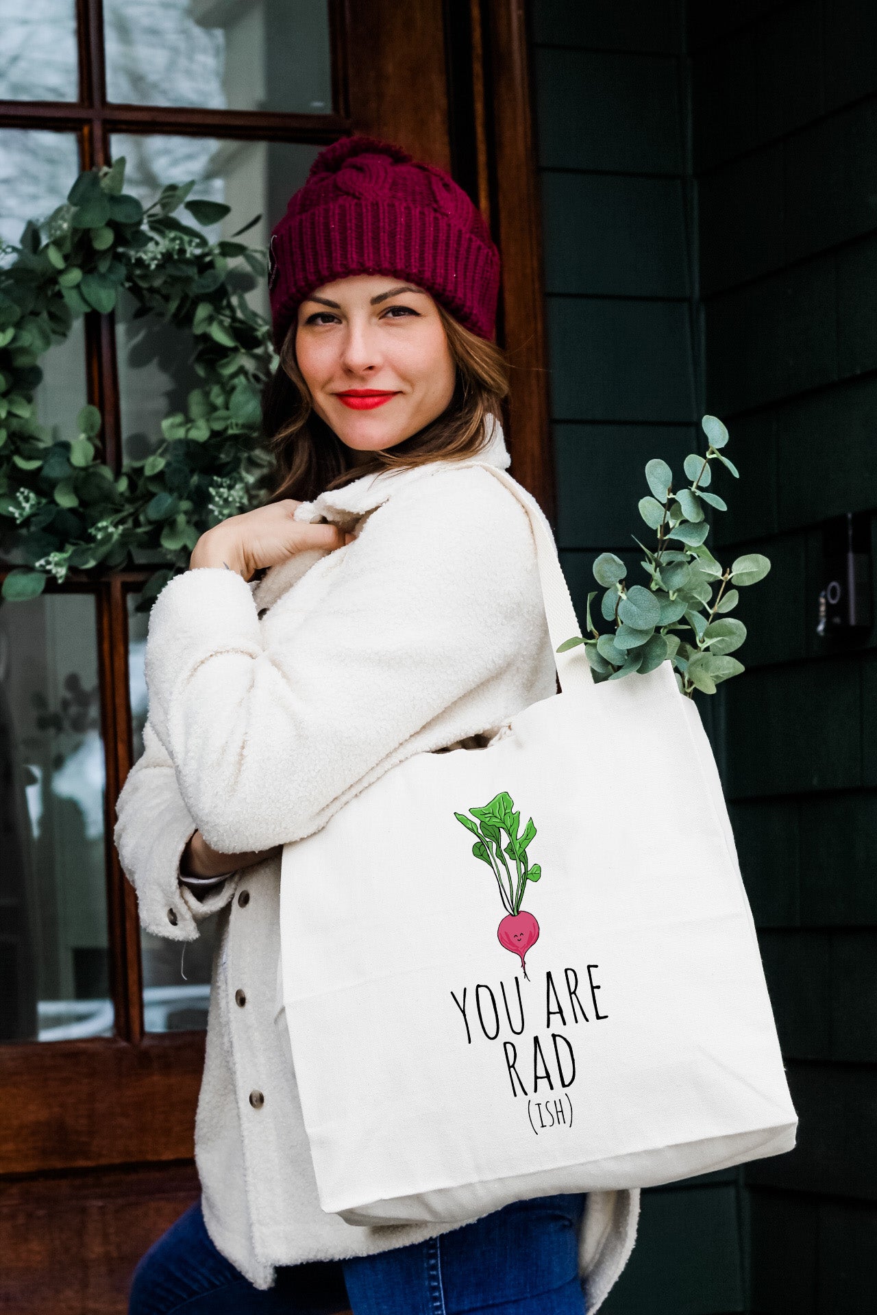 a woman carrying a white bag with a radish on it