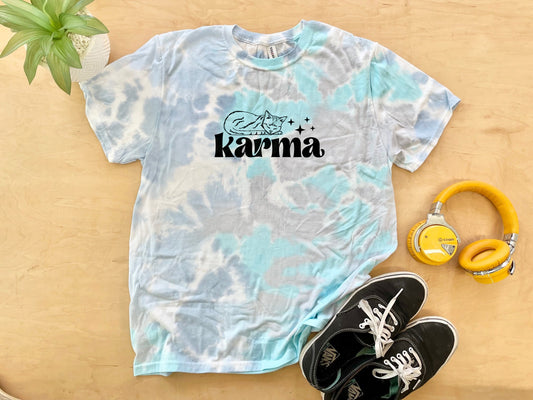 a tie dye shirt with the word karma on it next to headphones and a