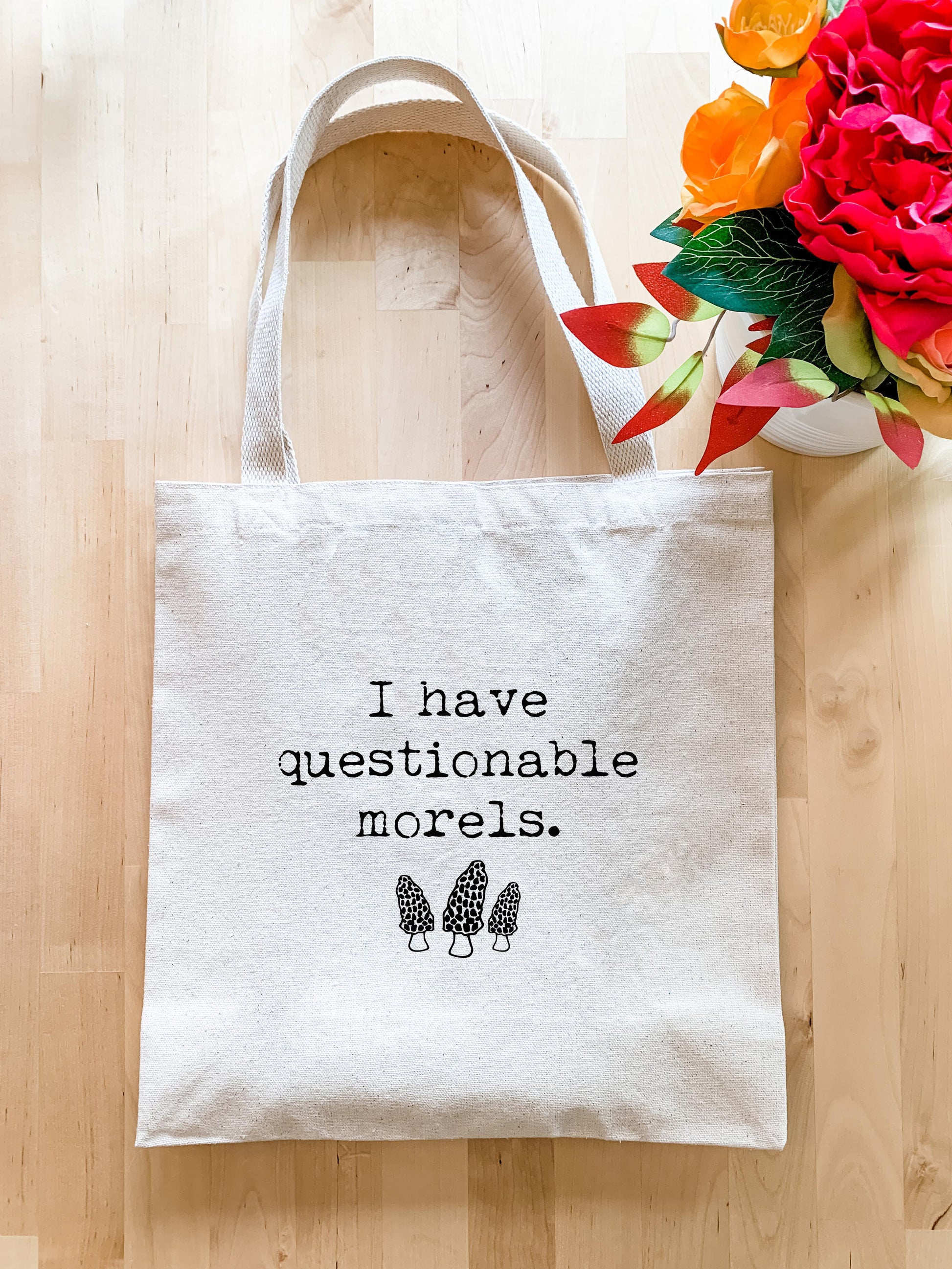 a white tote bag sitting on top of a wooden floor