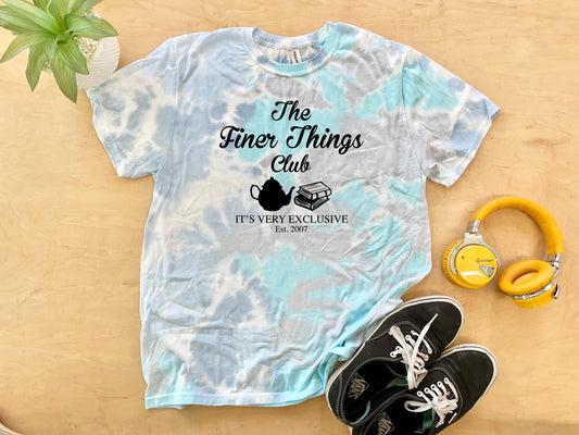 a t - shirt that says the finer things club next to a pair of head