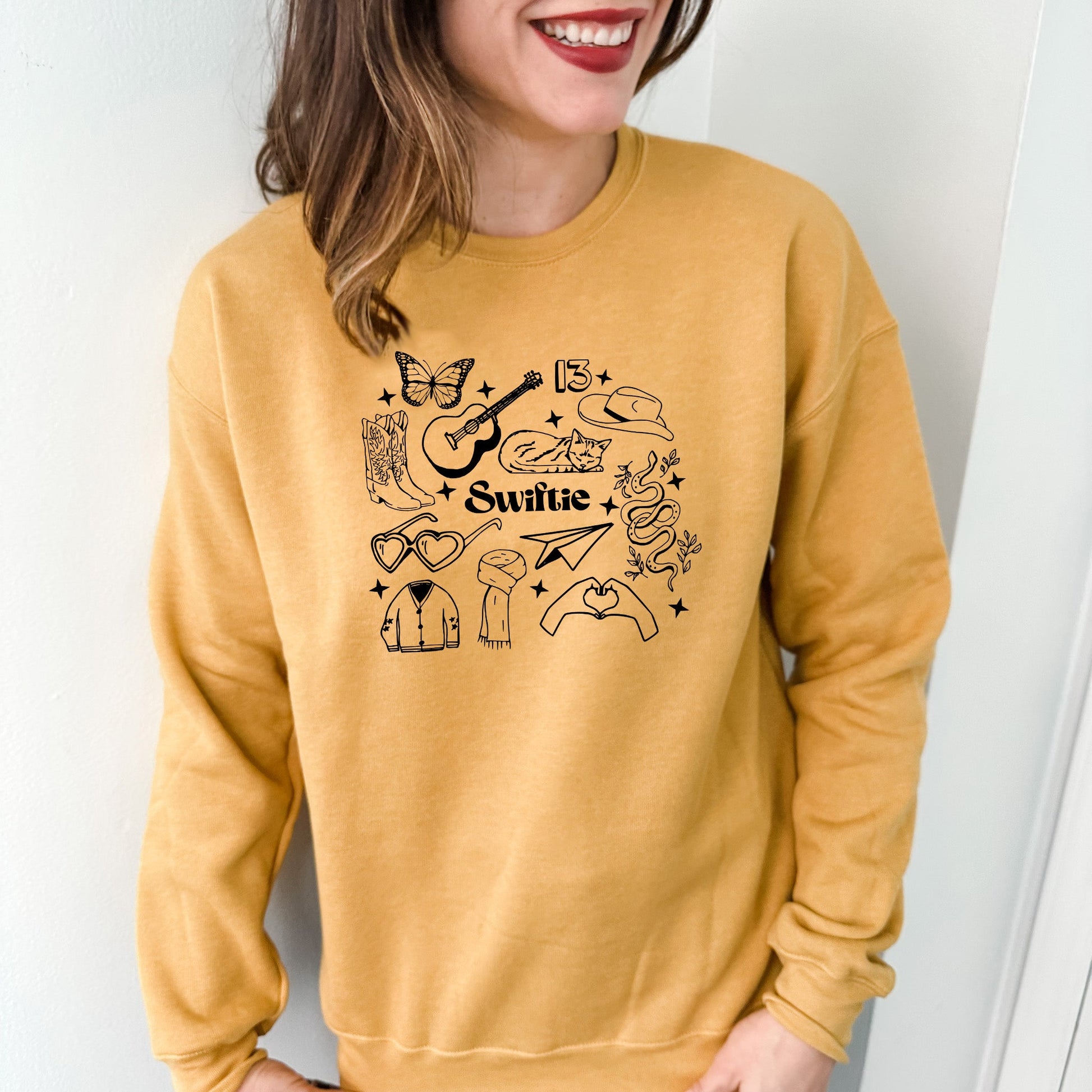 a woman wearing a yellow sweatshirt with a graphic on it