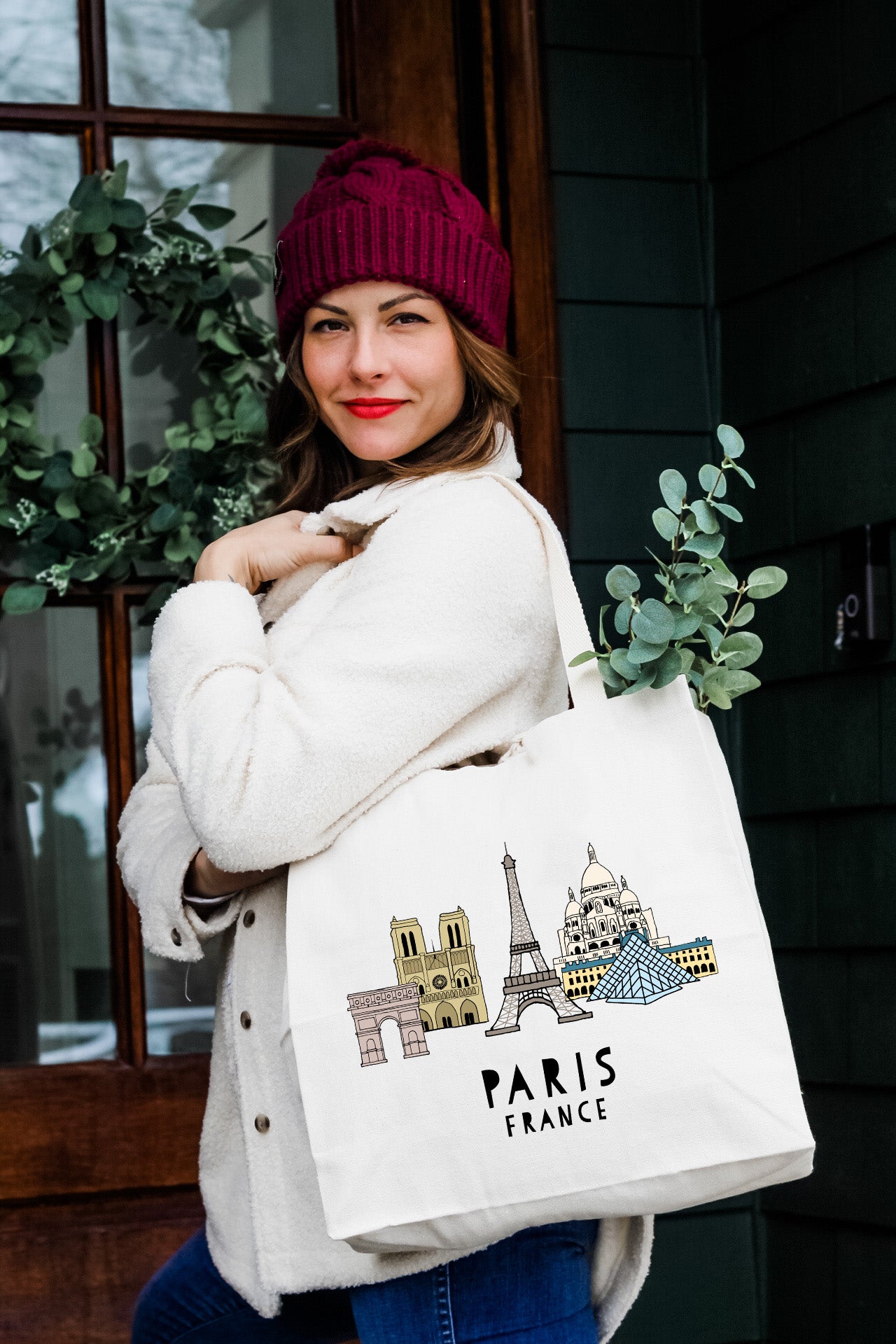 a woman carrying a white bag with a picture of the eiffel tower