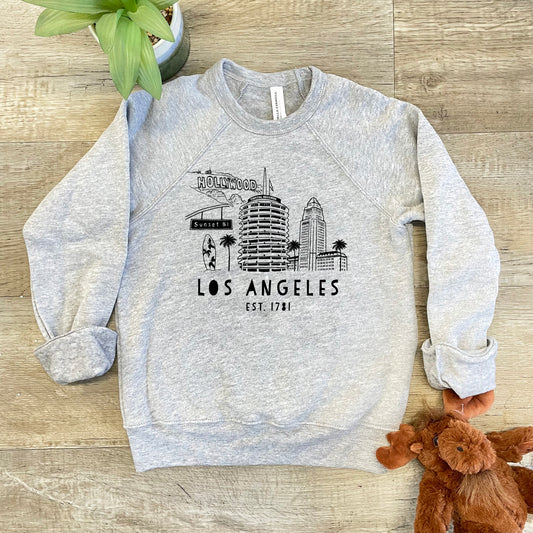 a sweatshirt with the los angeles skyline on it next to a teddy bear