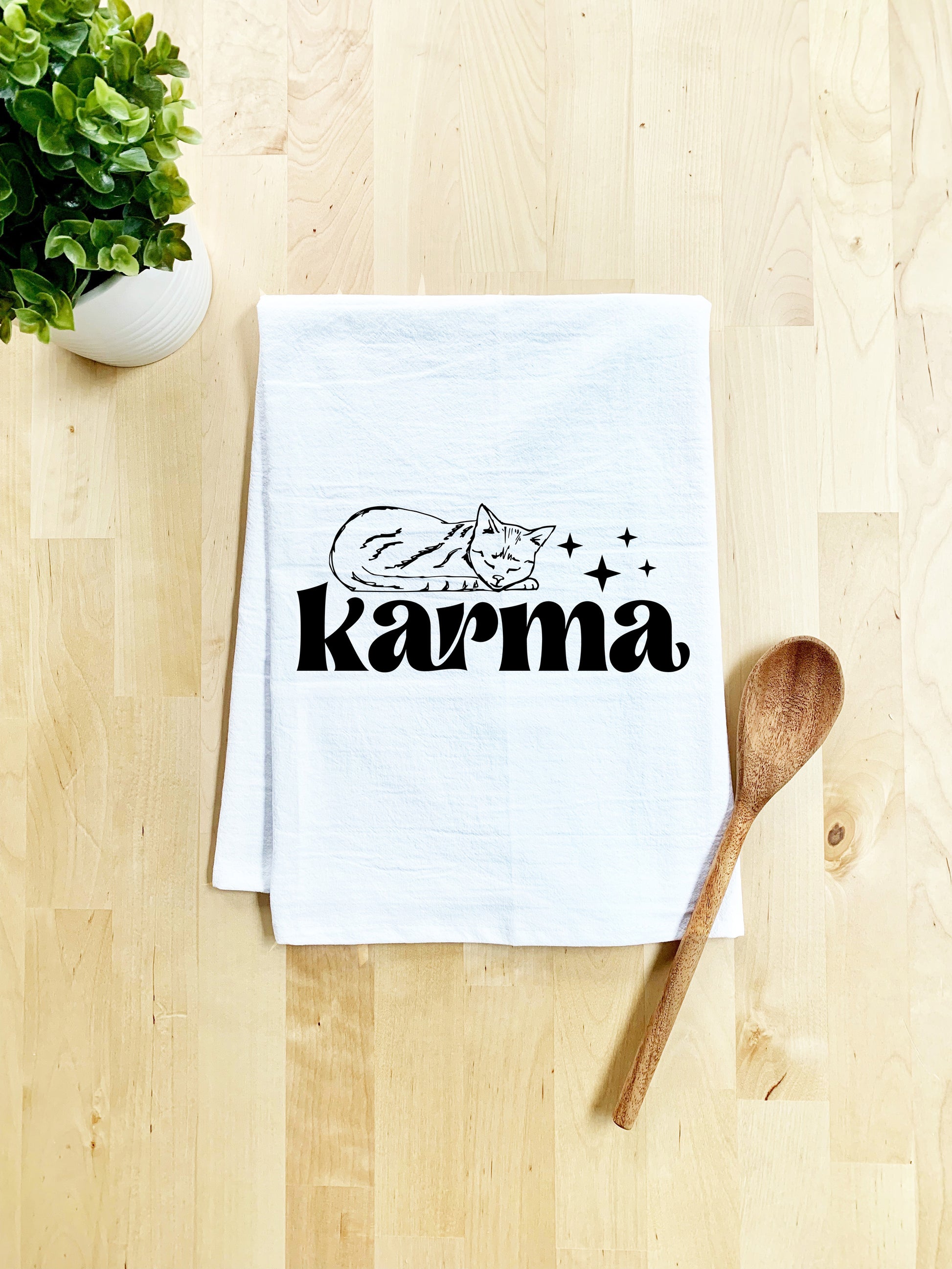 a tea towel with the word kazma on it next to a wooden spoon