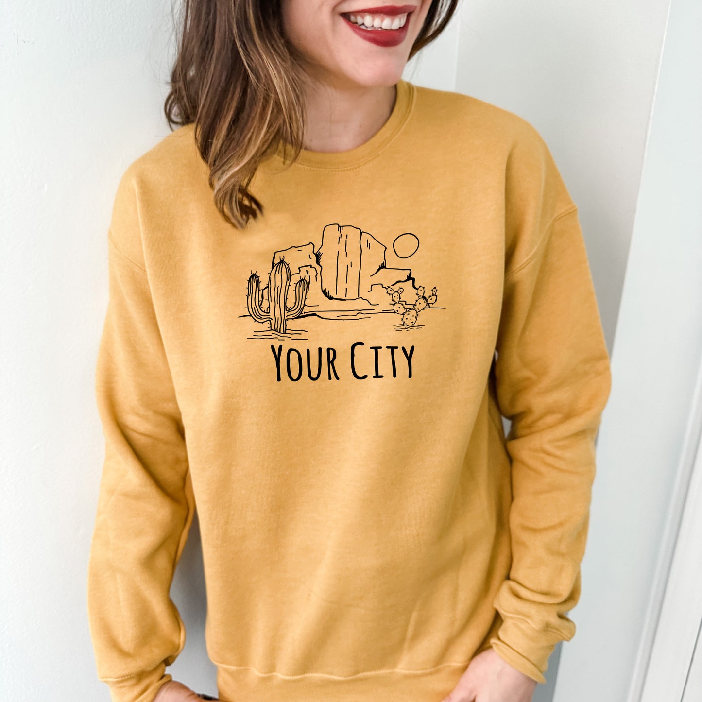 a woman wearing a yellow sweatshirt that says your city