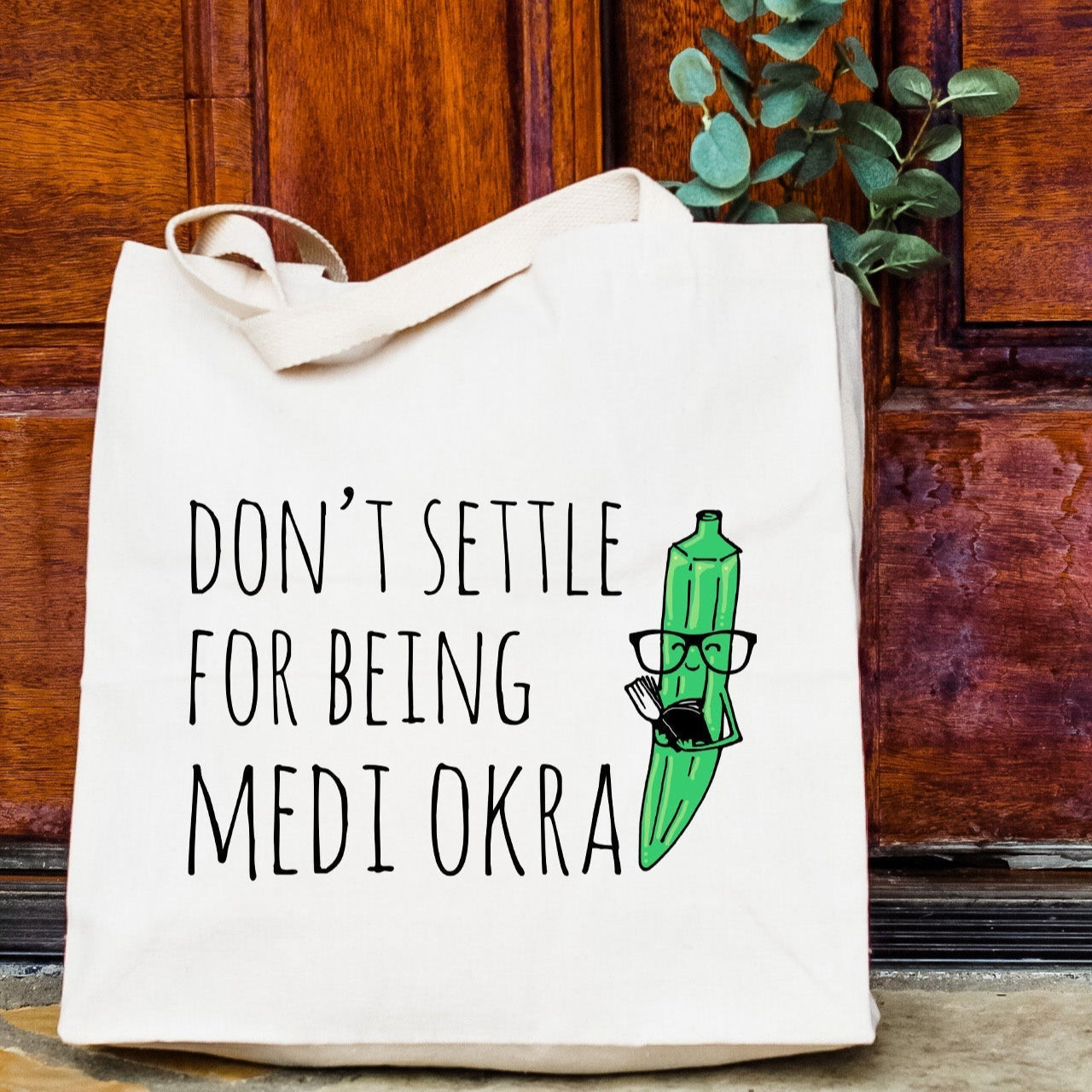 a tote bag sitting on the ground in front of a door