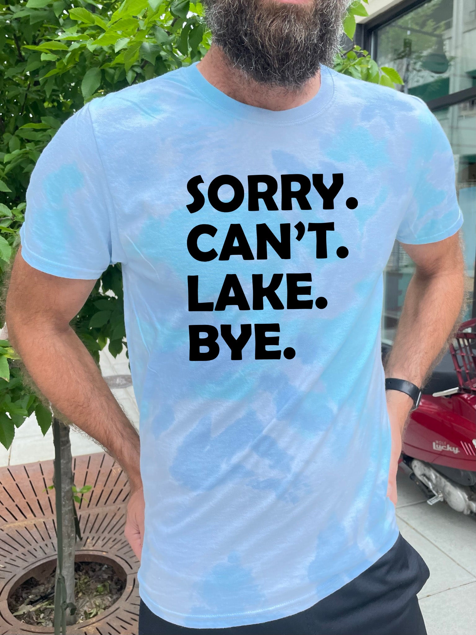 a man wearing a t - shirt that says sorry can't lake bye