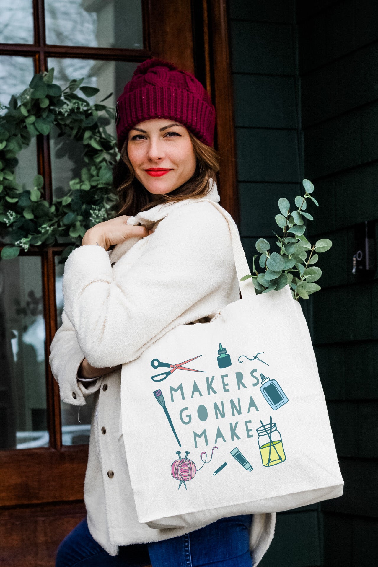a woman carrying a bag that says maker's donna make