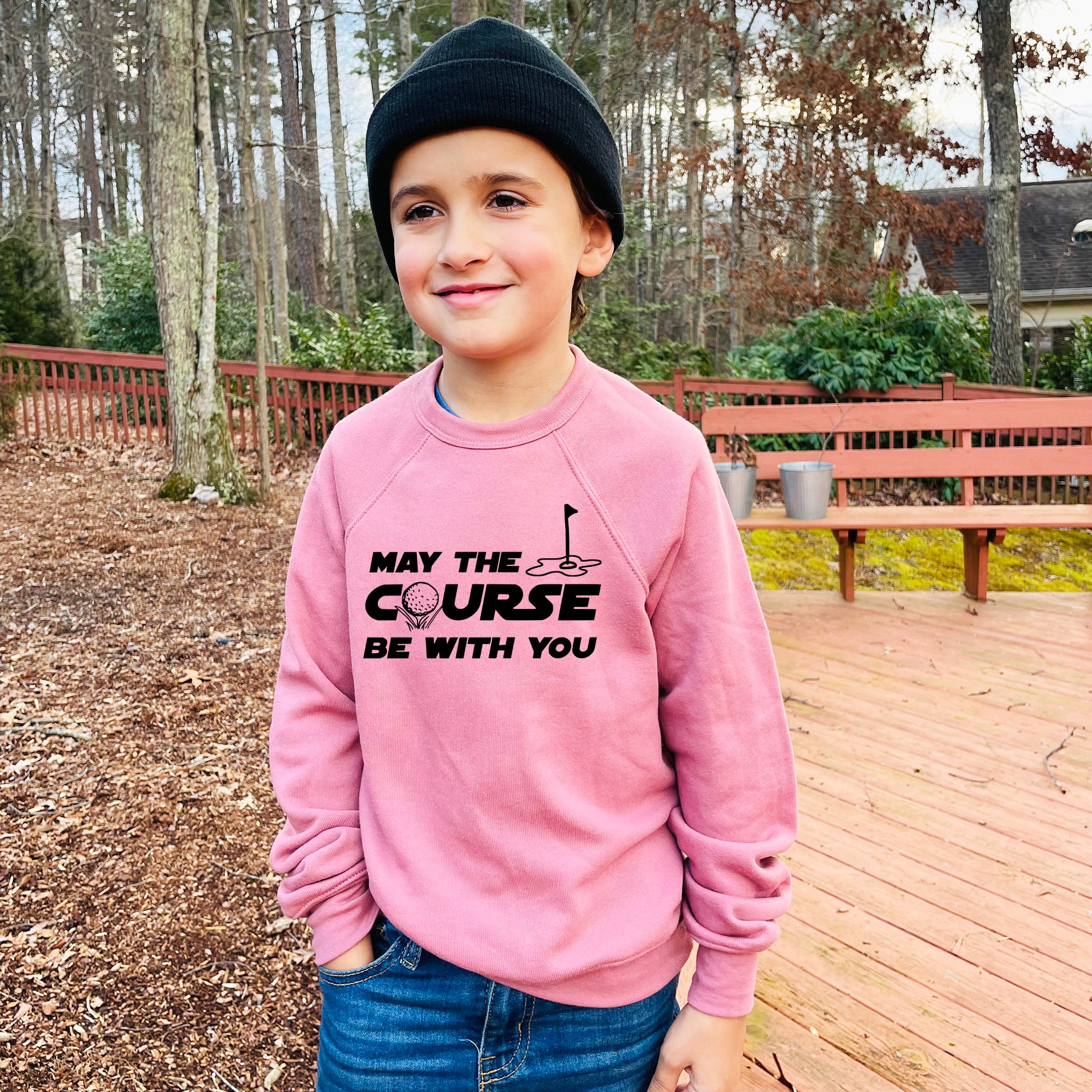 a young boy wearing a pink sweatshirt that says may the course be with you